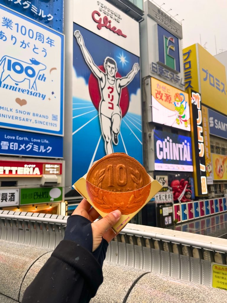 10-yen-pan_ 10-Yen Bread in Dotonbori with Glico Man in the background